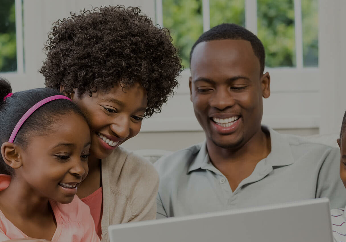 Family looking at laptop together.